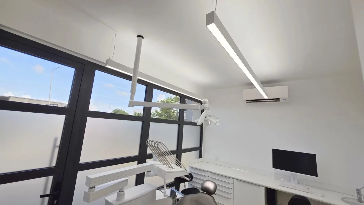 Moderner Behandlungsraum der Zahnarztpraxis Coral Dental Bonaire mit ausgewogener direkter und indirekter Beleuchtung durch Dentled PHL22 LED-Leuchten.